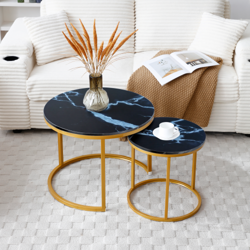 Black marble-look nesting tables with gold metal frames beside a white sofa